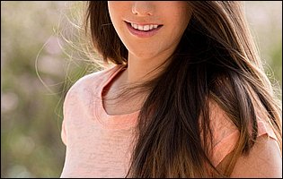 Young beauty Eva Lovia in t-shirt strips and poses naked outdoor