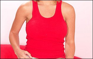 Jasmine Tame in red t-shirt strips for camera