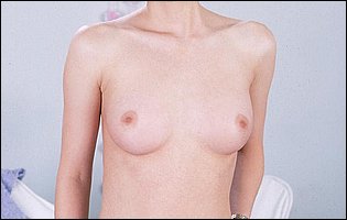 Young Justine Joli in t-shirt and jeans strips and poses naked for camera