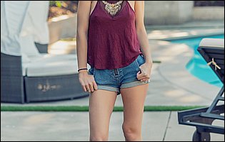 Macy Meadows in t-shirt and denim shorts strips outdoor