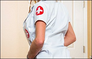 Nadia Hilton in nurse outfit and heels posing in front of the camera