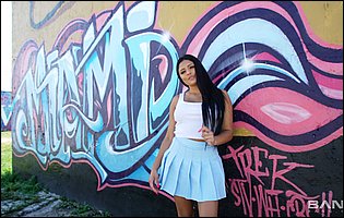 Busty brunette Serena Santos posing in pink panties and white sneakers