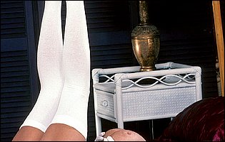 Summer Cummings poses in white lingerie, stockings and high heels